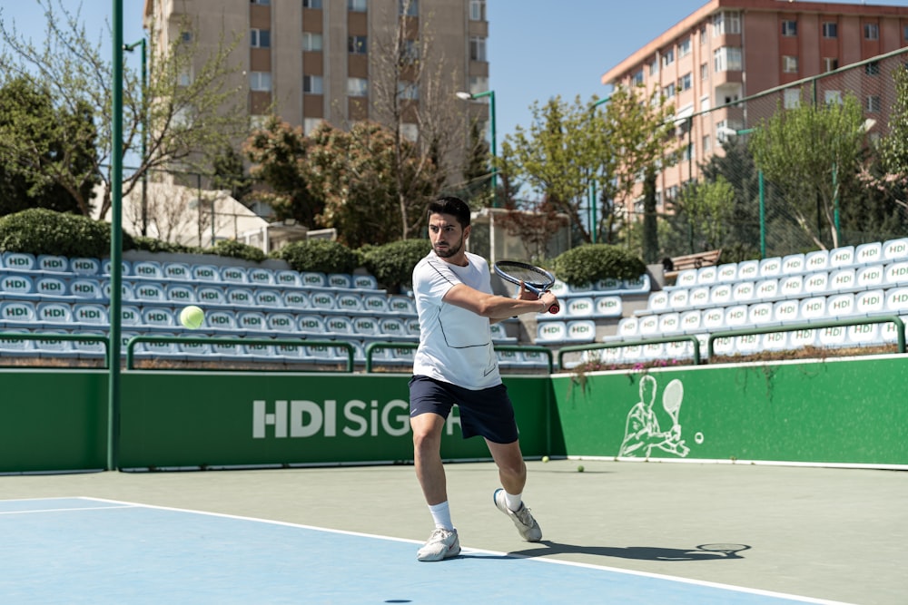 a man swinging a tennis racquet on a tennis court