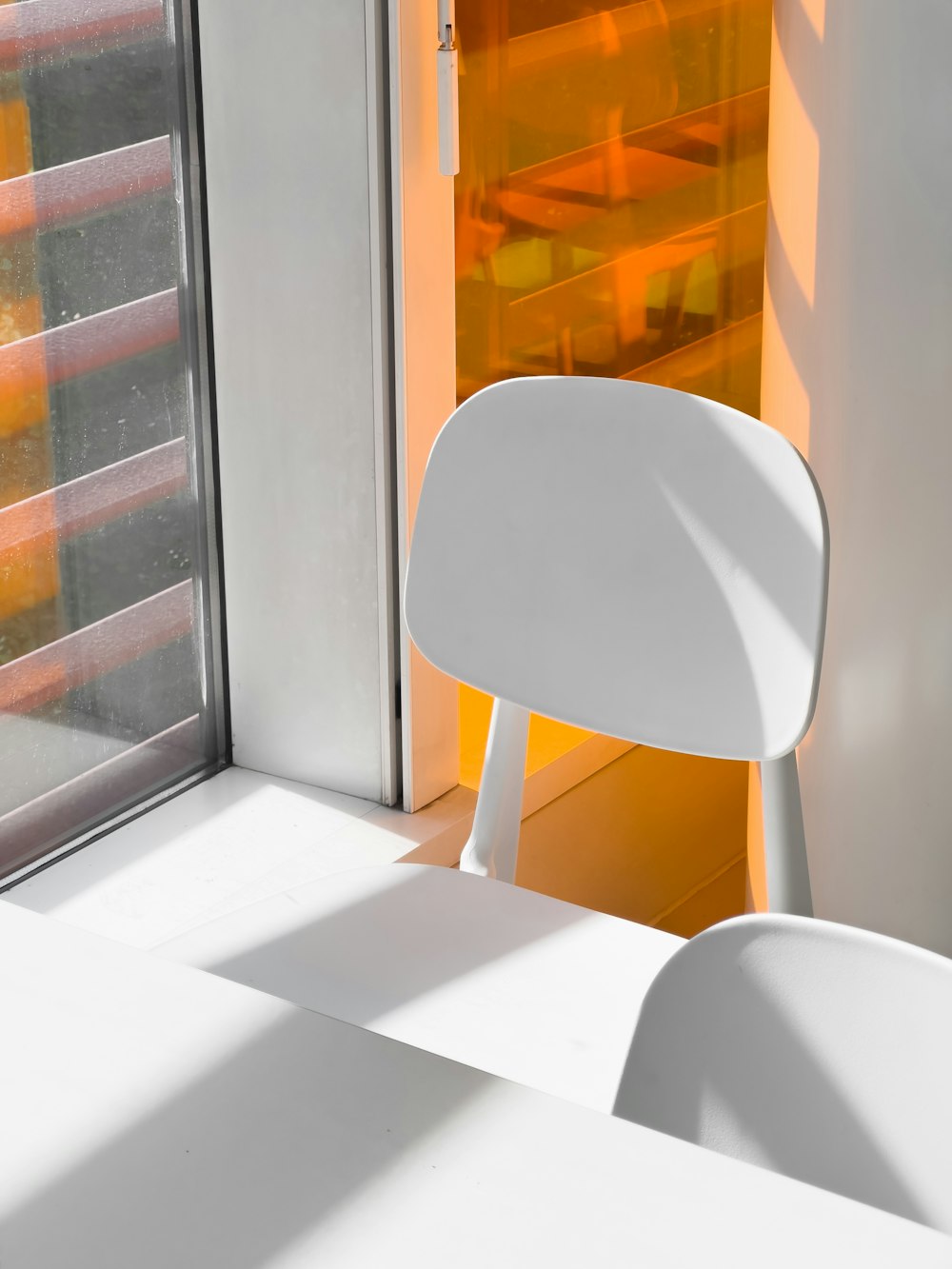 a white chair sitting in front of a window