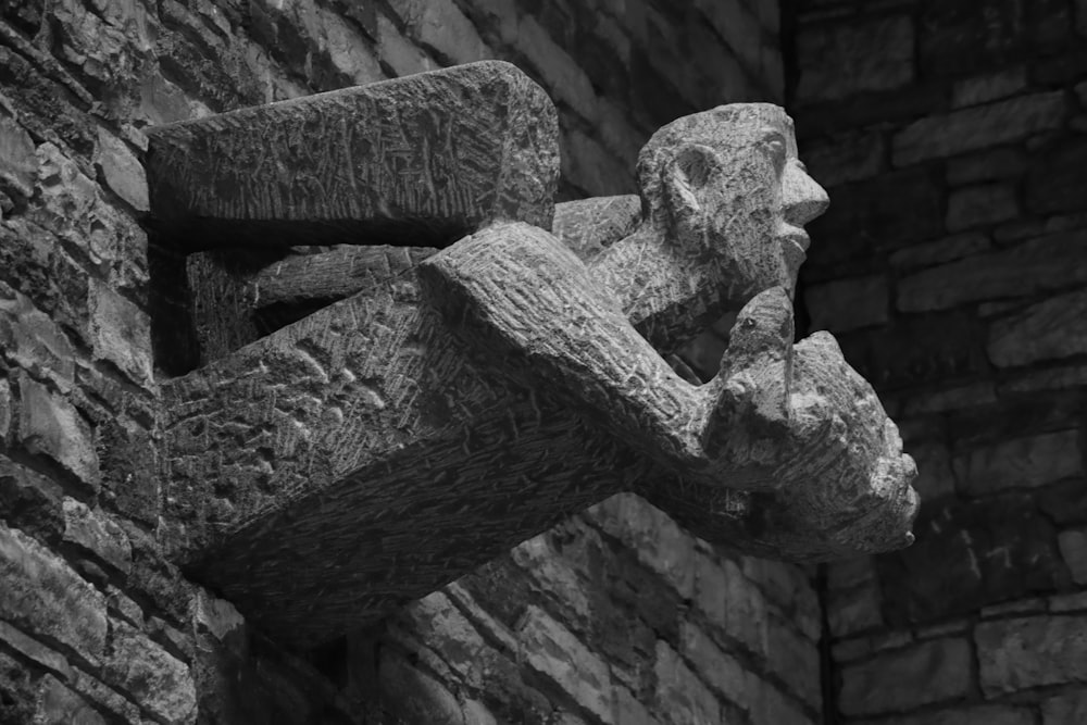 a sculpture of a human head on a brick wall