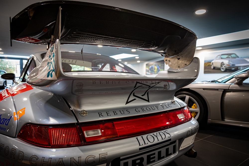 the back of a silver sports car in a showroom