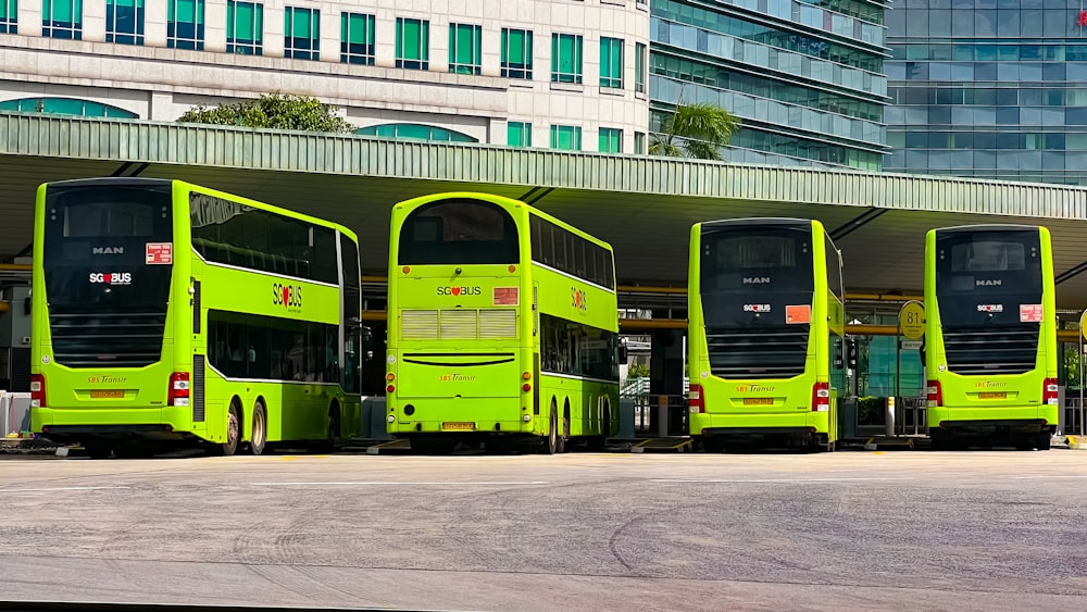 a row of green double decker buses parked next to each other