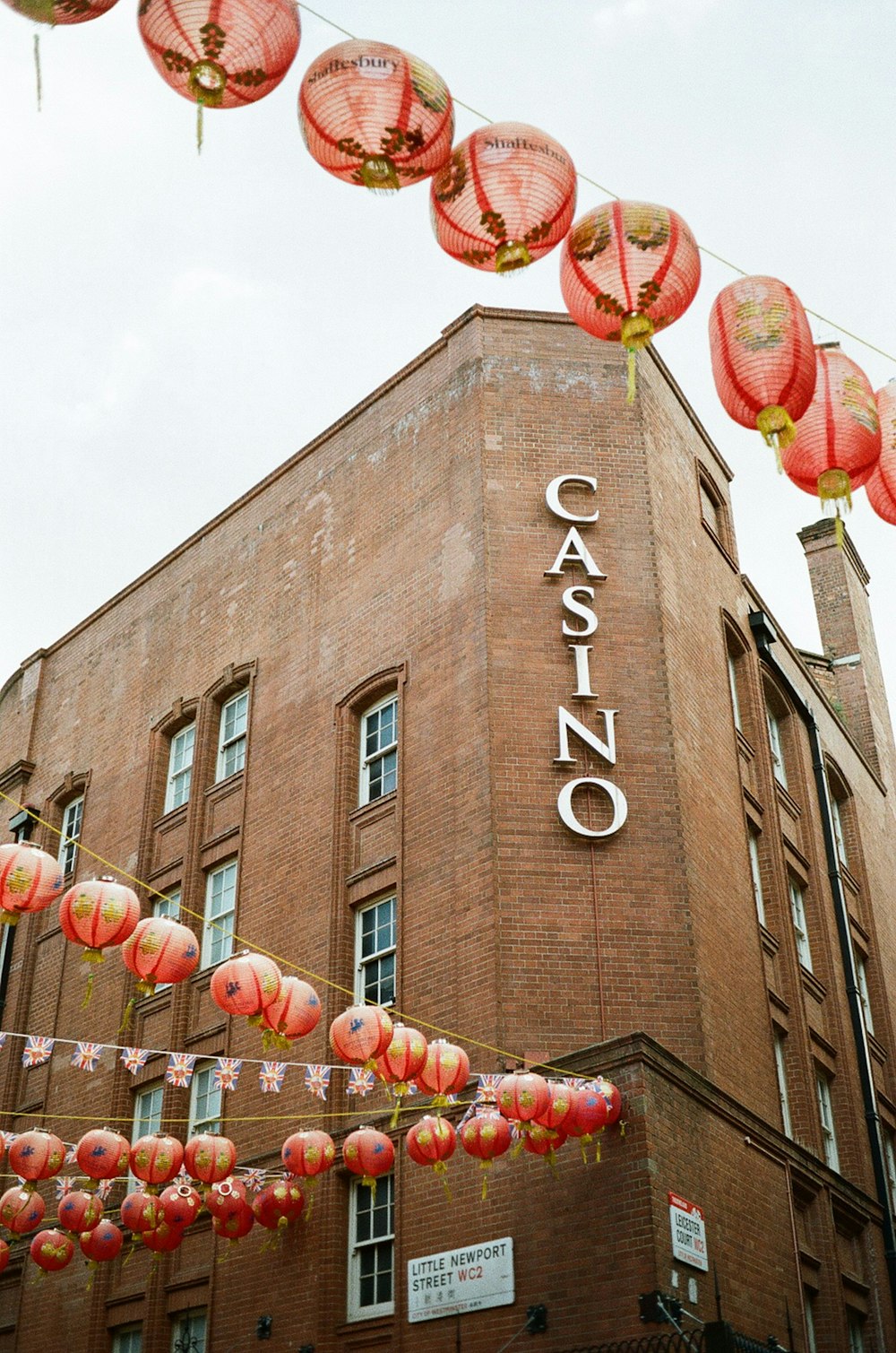 a building with red lanterns hanging from it's side