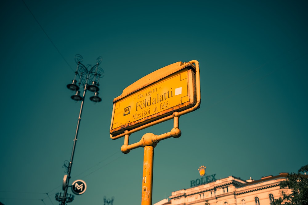 a yellow street sign sitting next to a traffic light