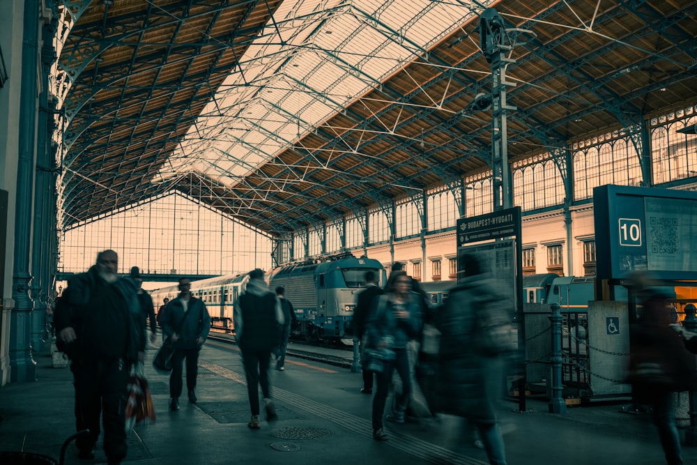 a group of people walking around a train station