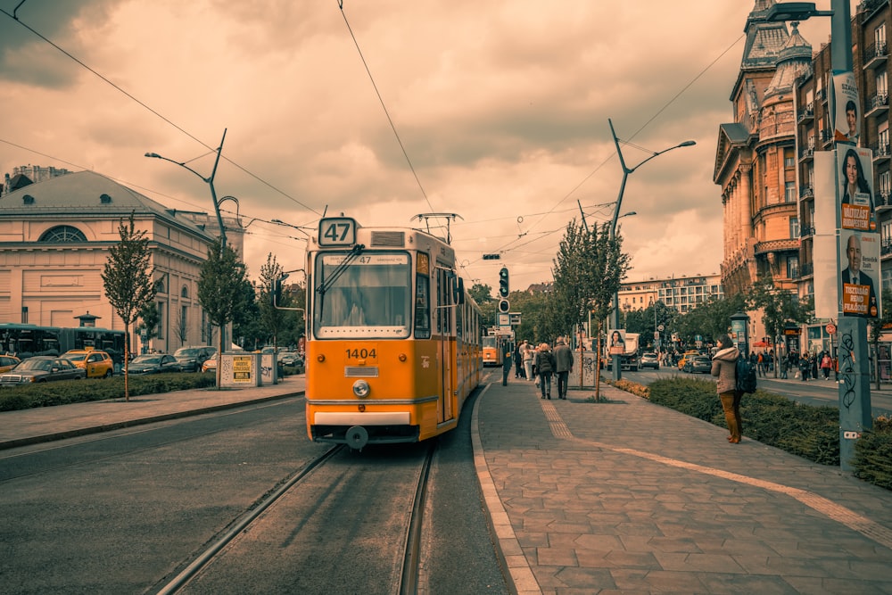 a yellow trolley car on a city street