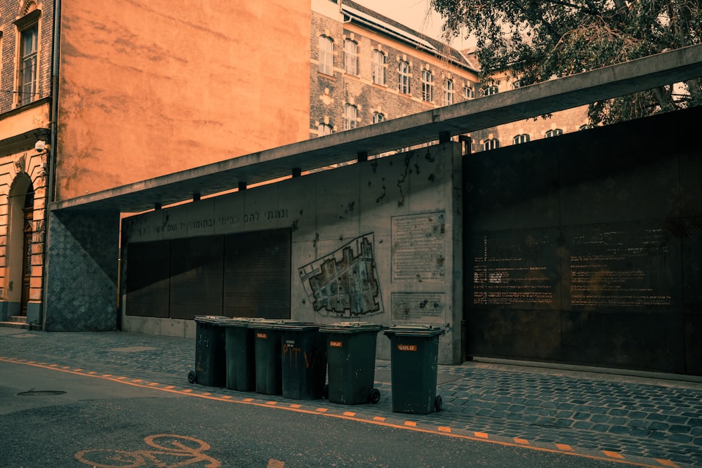 a couple of trash cans sitting on the side of a road