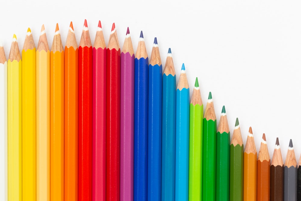 a row of colored pencils on a white background