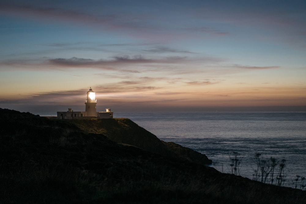 a lighthouse on a hill overlooking the ocean