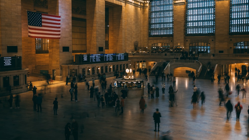 a group of people walking around a train station