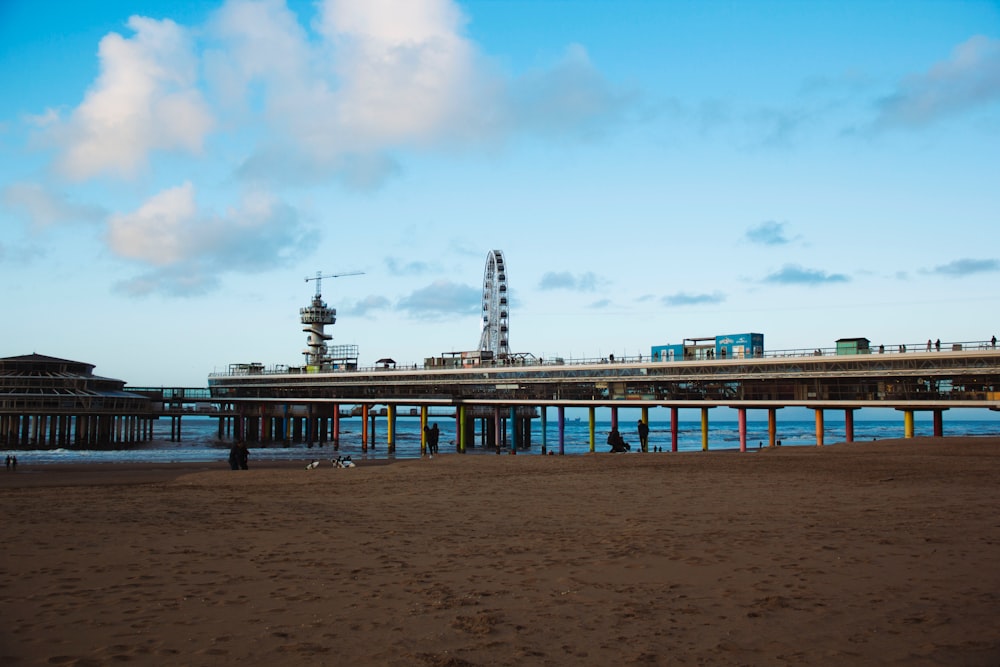 a pier on a beach with a sky background