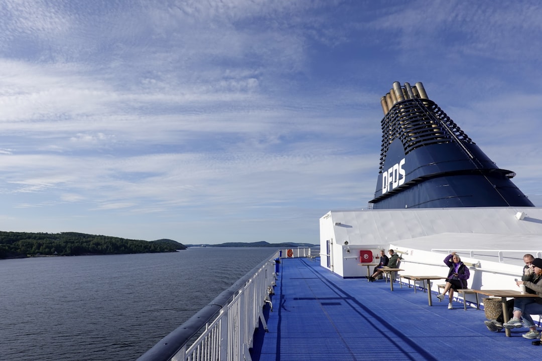 people sitting on benches on the deck of a cruise ship,