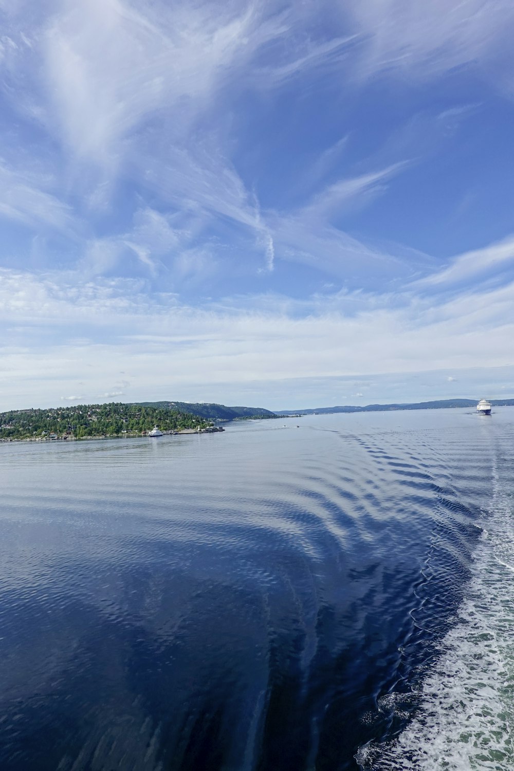 a large body of water with a boat in the distance