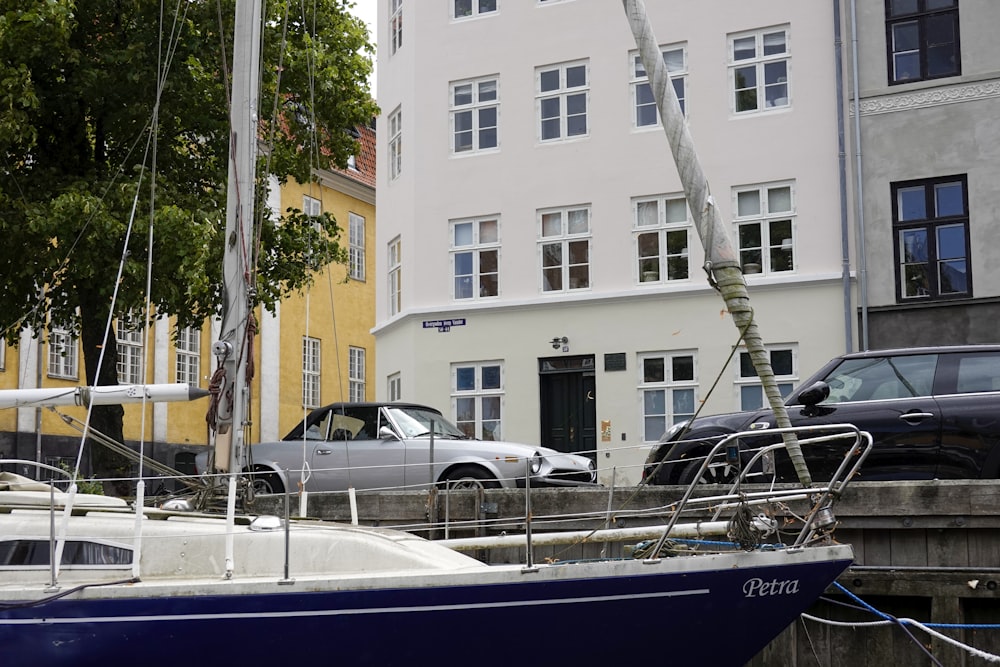 a blue and white boat parked in front of a white building