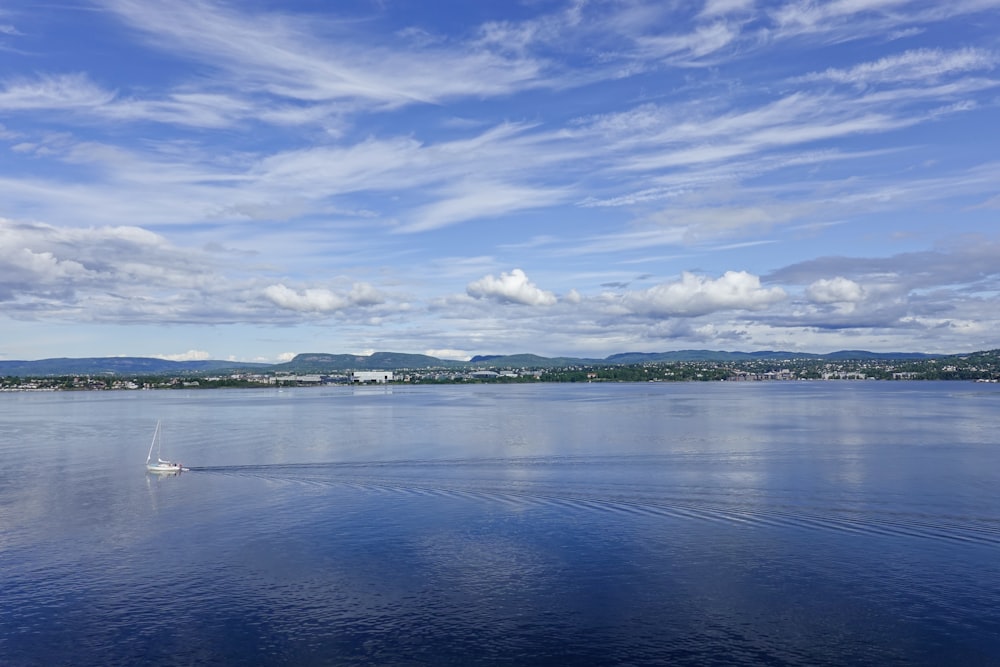 a small boat is in the middle of a large body of water