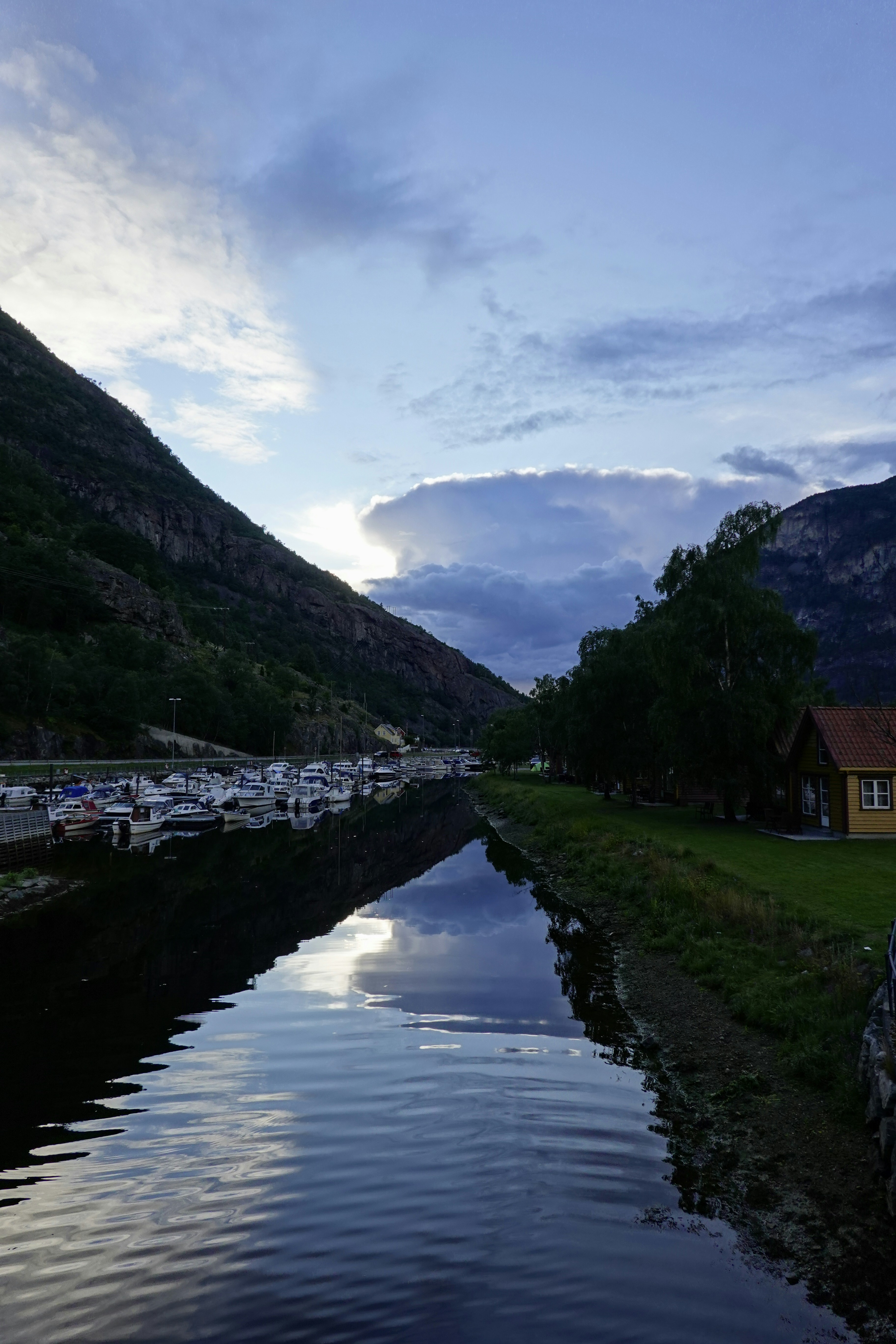 ein Gewässer neben einem saftig grünen Hügel