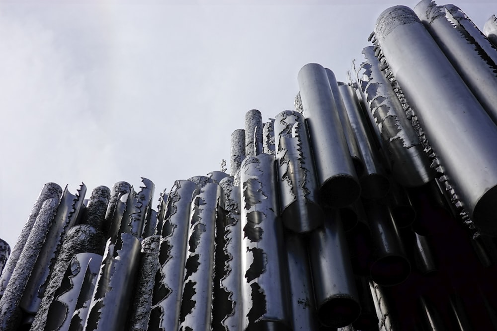 a large stack of metal pipes sitting next to each other