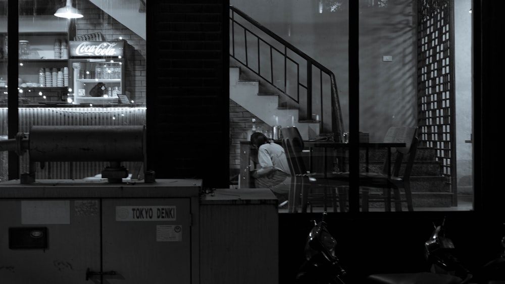 a man standing in front of a counter in a restaurant