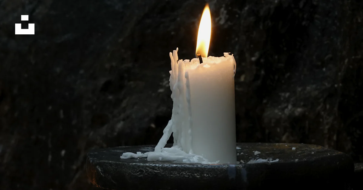 Uma vela acesa sentada em cima de uma bandeja preta foto – Imagem ...