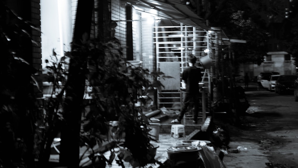 a black and white photo of a man on a ladder