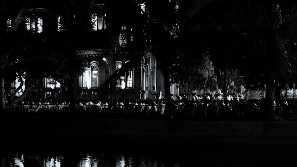 a group of people standing in front of a building at night