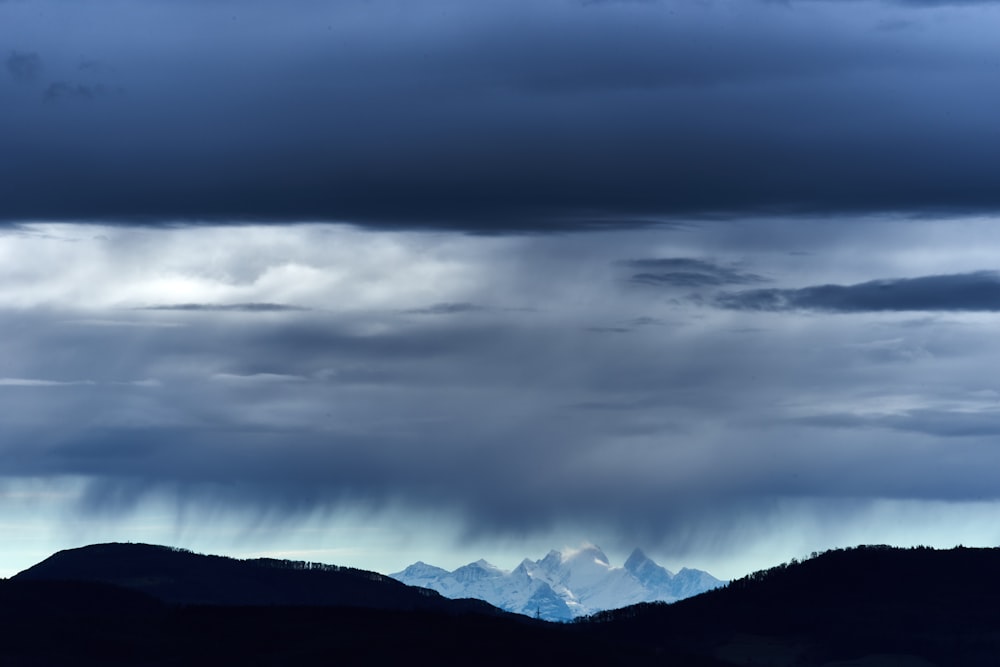 a view of a mountain range under a cloudy sky