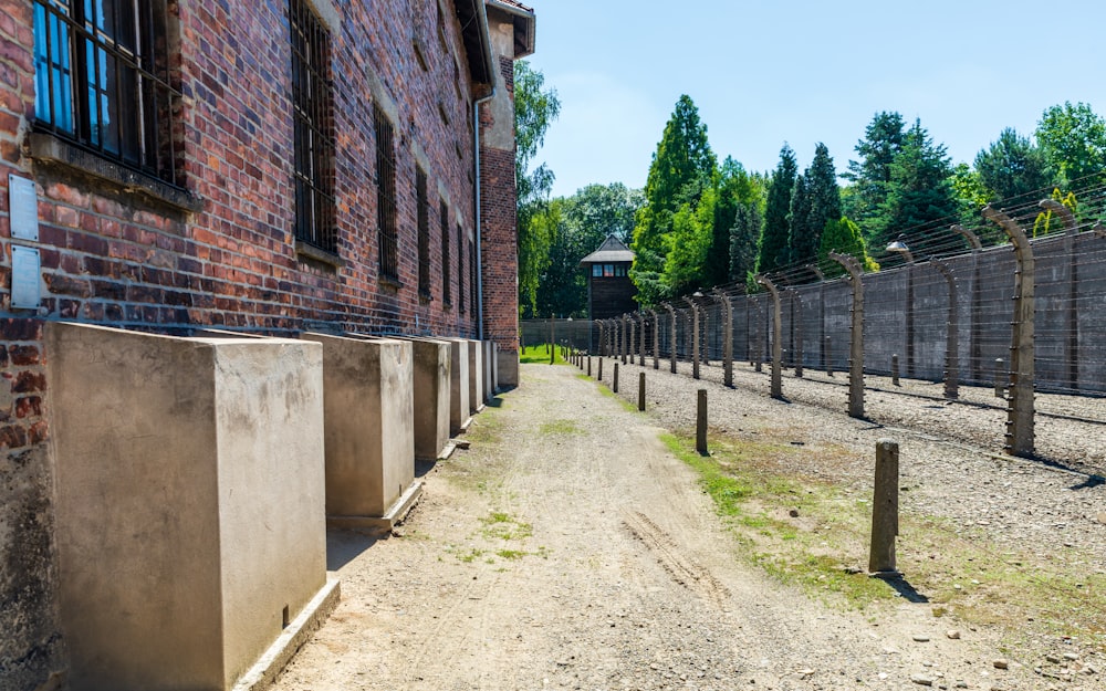 a dirt road next to a brick building