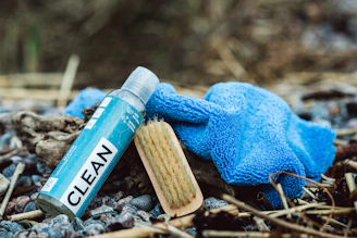 a close up of a blue glove and a tube of clean