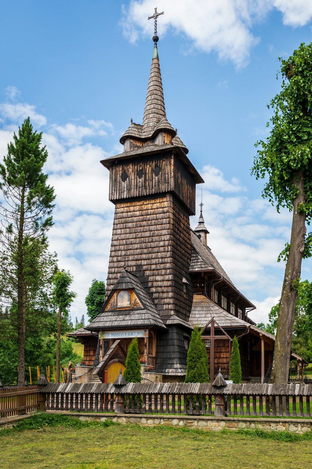 a wooden church with a steeple and a cross on top