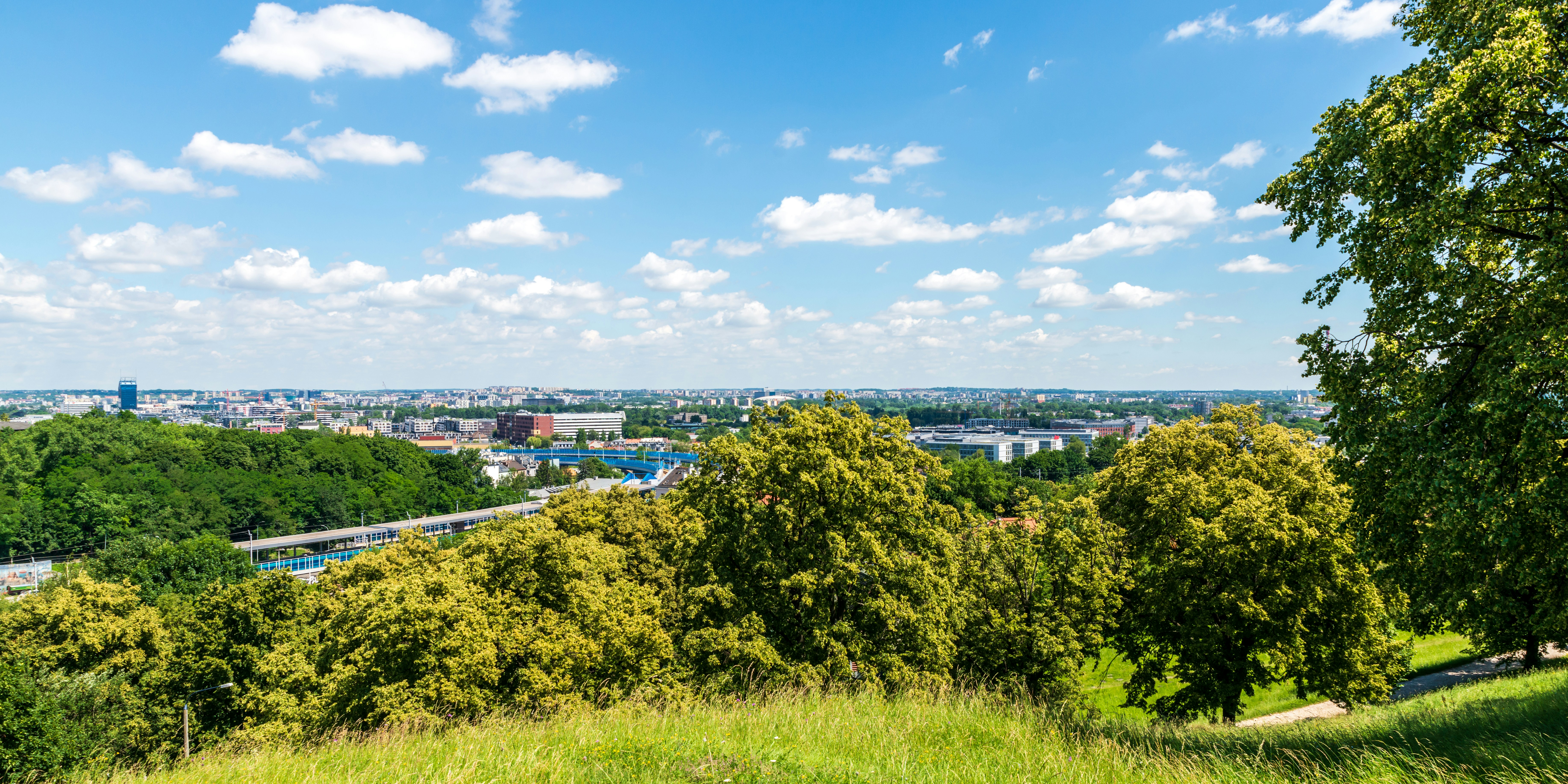 View of Kraków, Poland, seen from Krakus Mound. On a warm summer day like this, the blue sky and light clouds above adds to the beauty of the scenery.