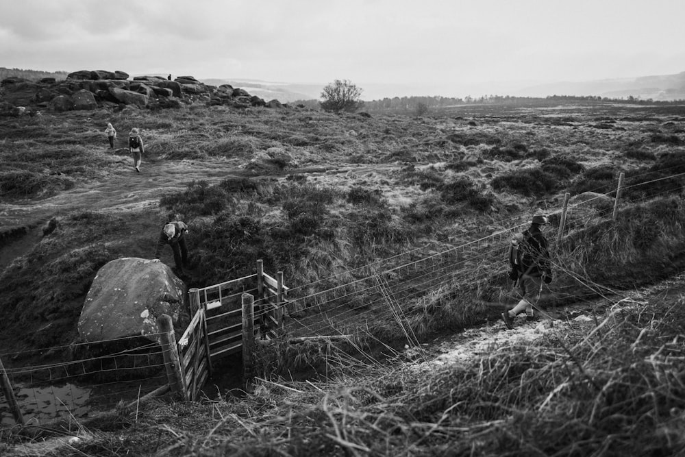 a black and white photo of people walking up a hill