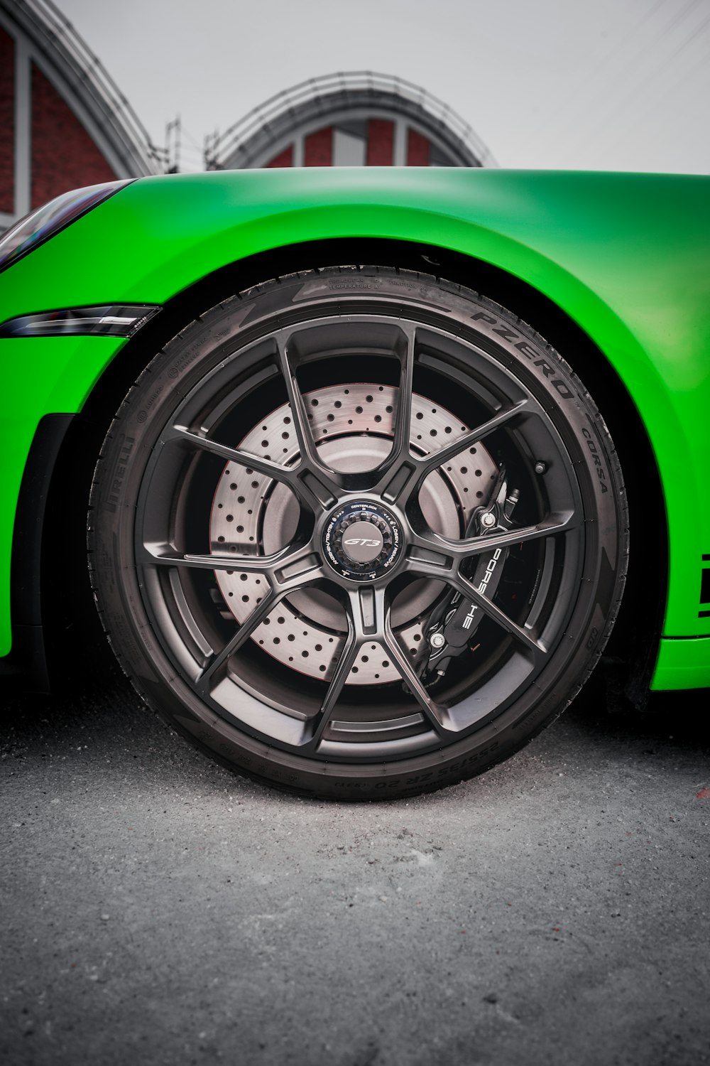 a green sports car parked in front of a building