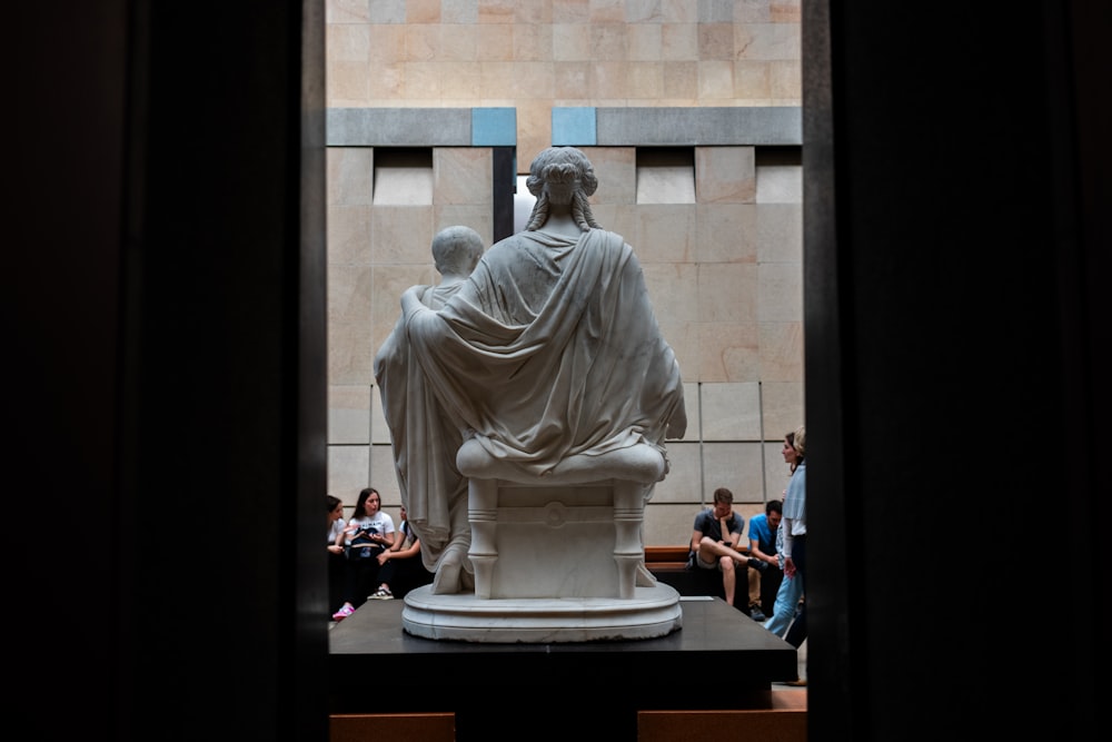 a group of people sitting around a statue