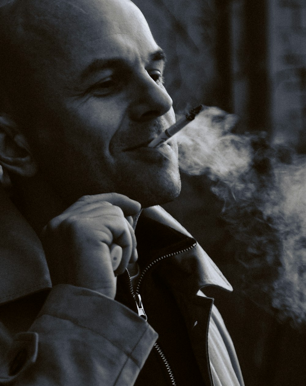 a man smoking a cigarette in a black and white photo