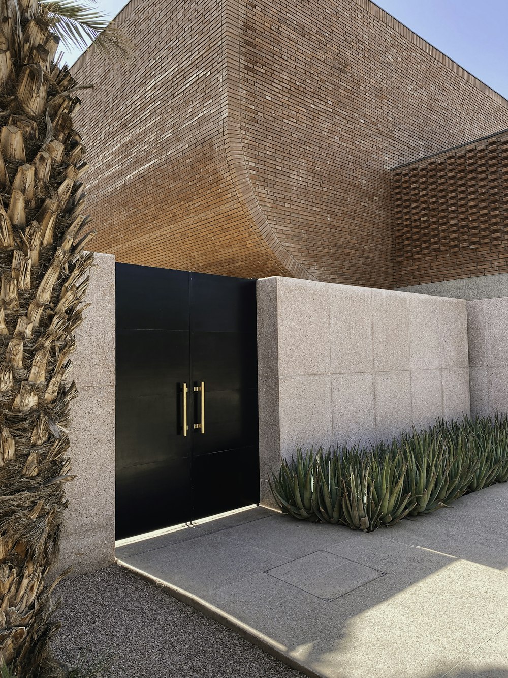 a building with a black door and some plants