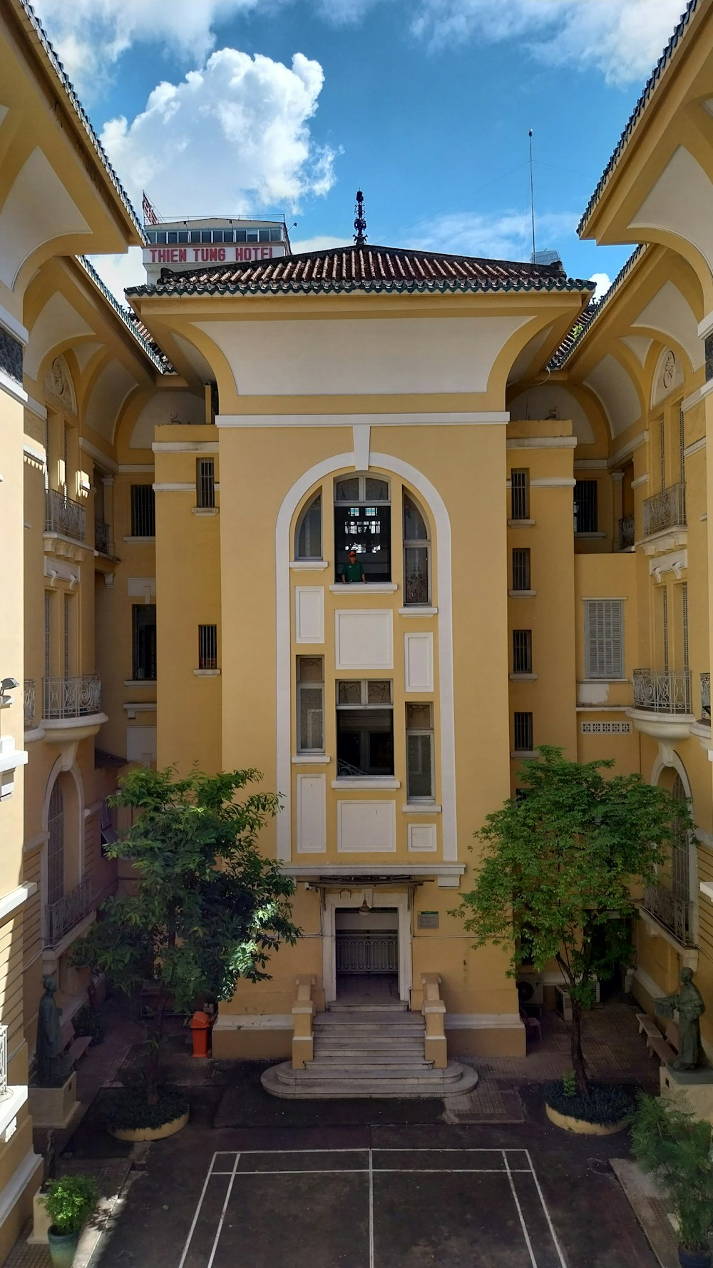 a tennis court in front of a yellow building