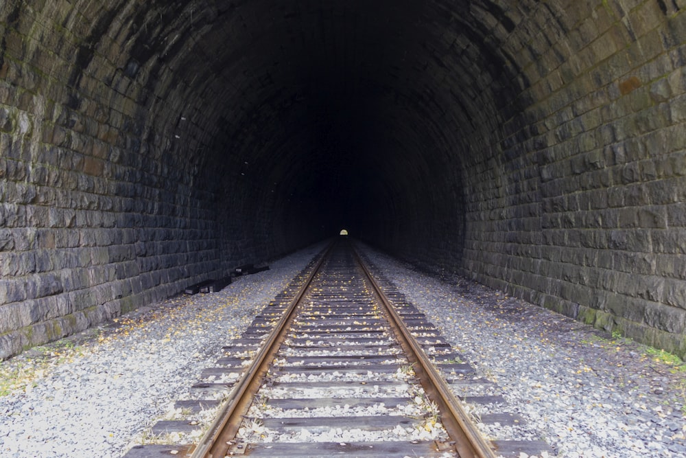 a train track going into a dark tunnel