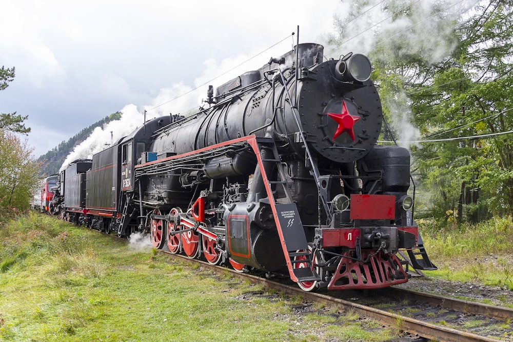 a black and red train traveling down train tracks