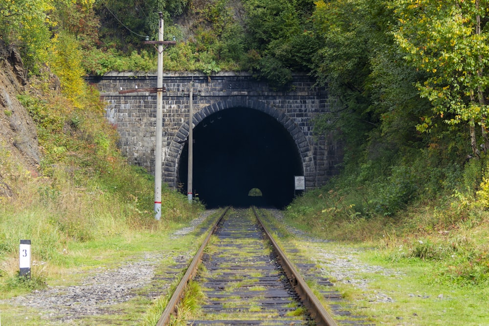 a train track going into a dark tunnel