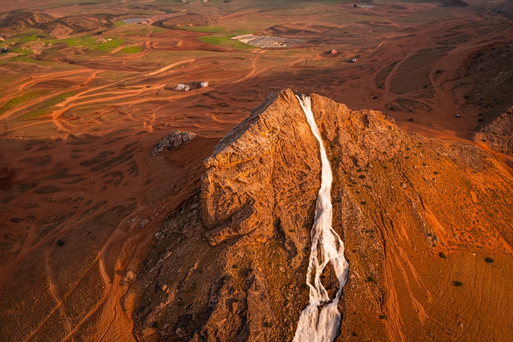 an aerial view of a mountain with a stream running through it