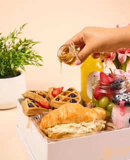 a person is pouring honey into a box of food