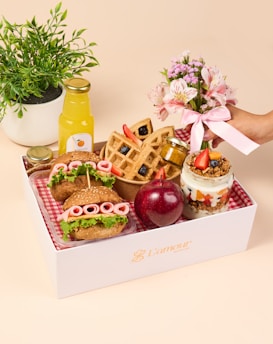 a white box filled with food and a potted plant
