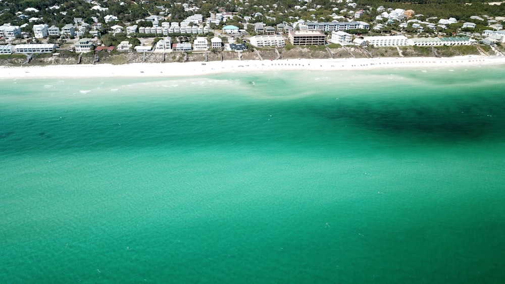 an aerial view of a beach with houses in the background