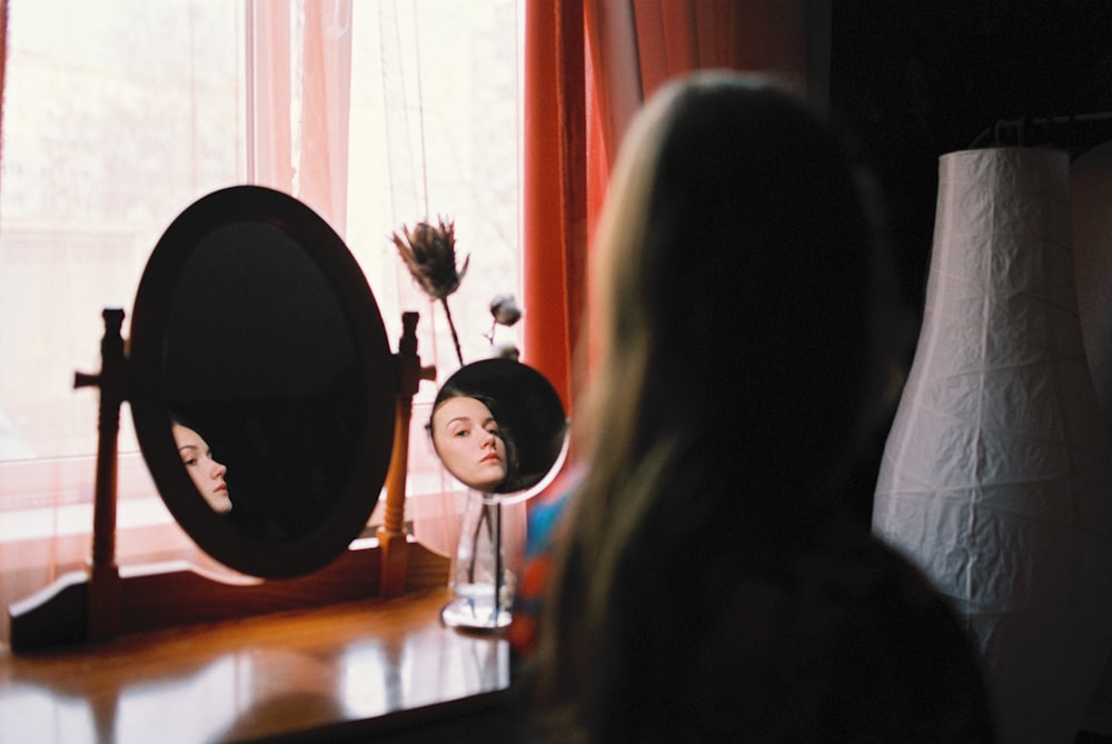 a woman looking at her reflection in a mirror