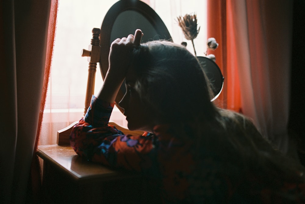 a woman is sitting in front of a mirror