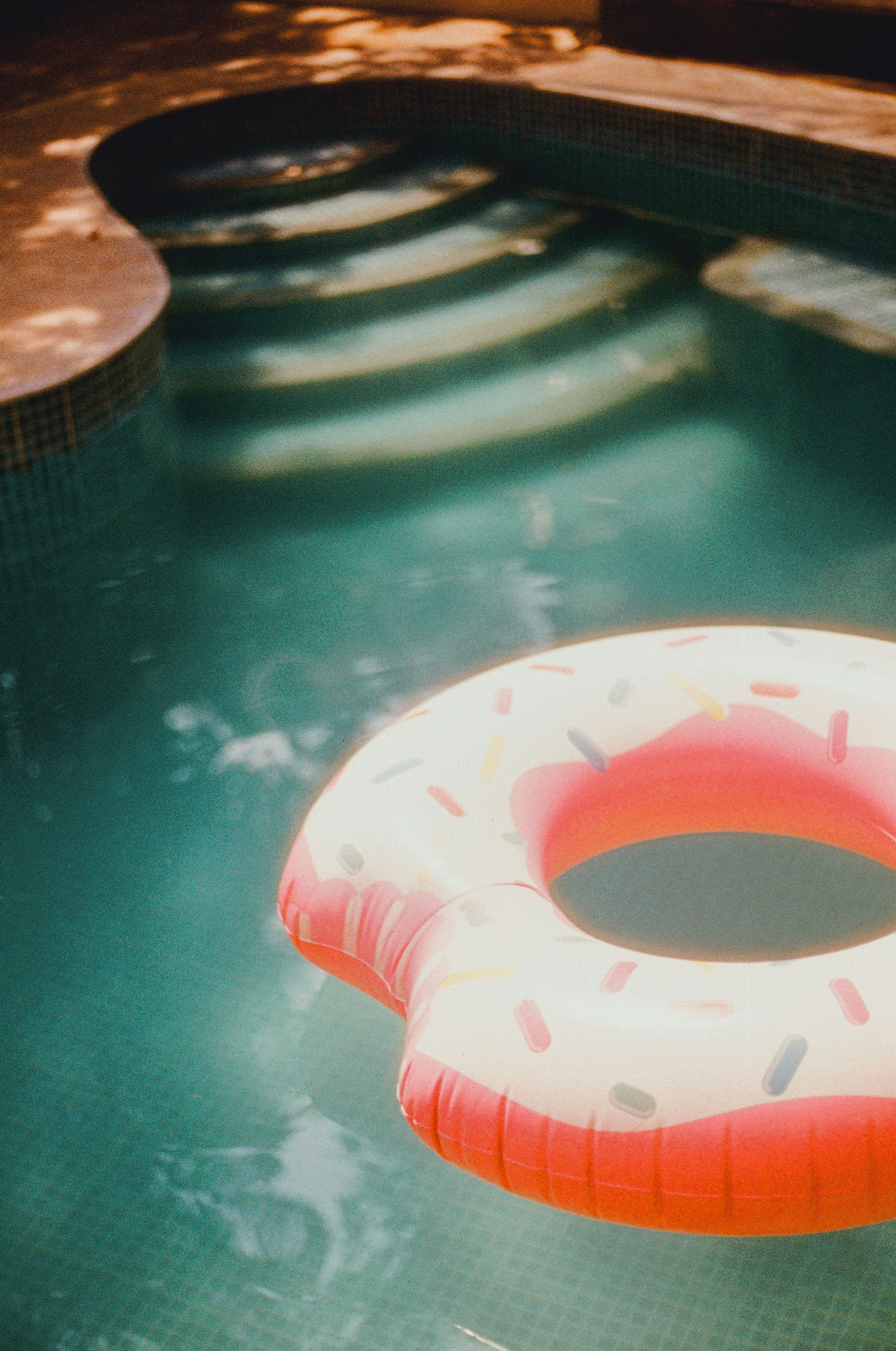 ein aufblasbarer Donut, der in einem Pool schwimmt
