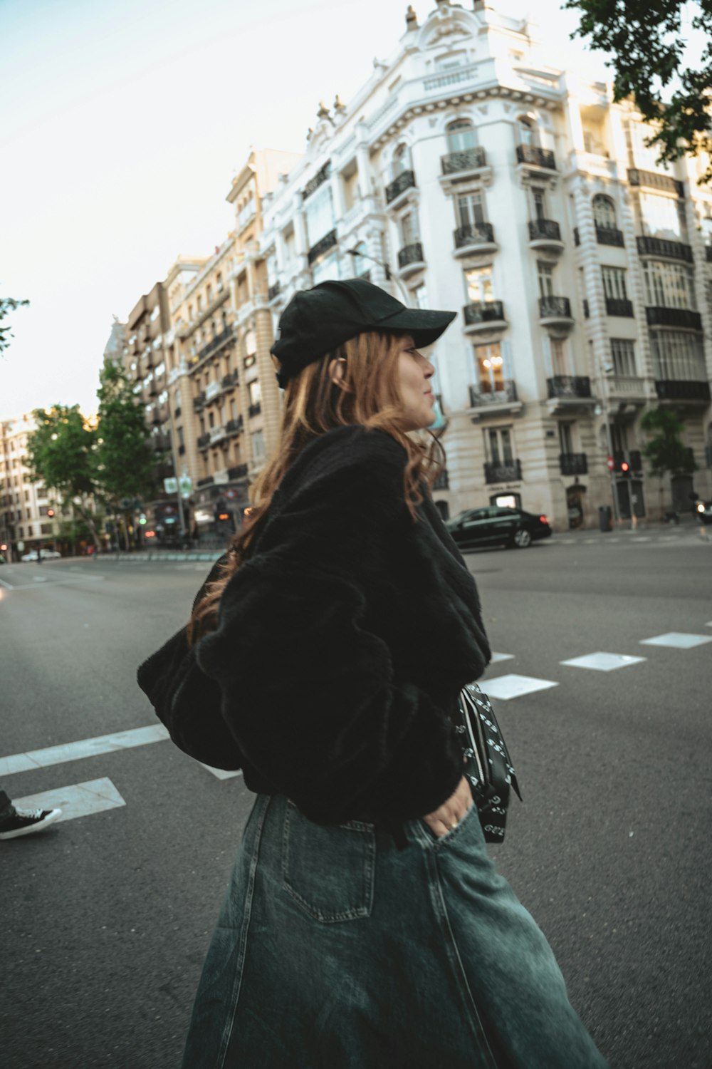 a woman walking down a street next to tall buildings