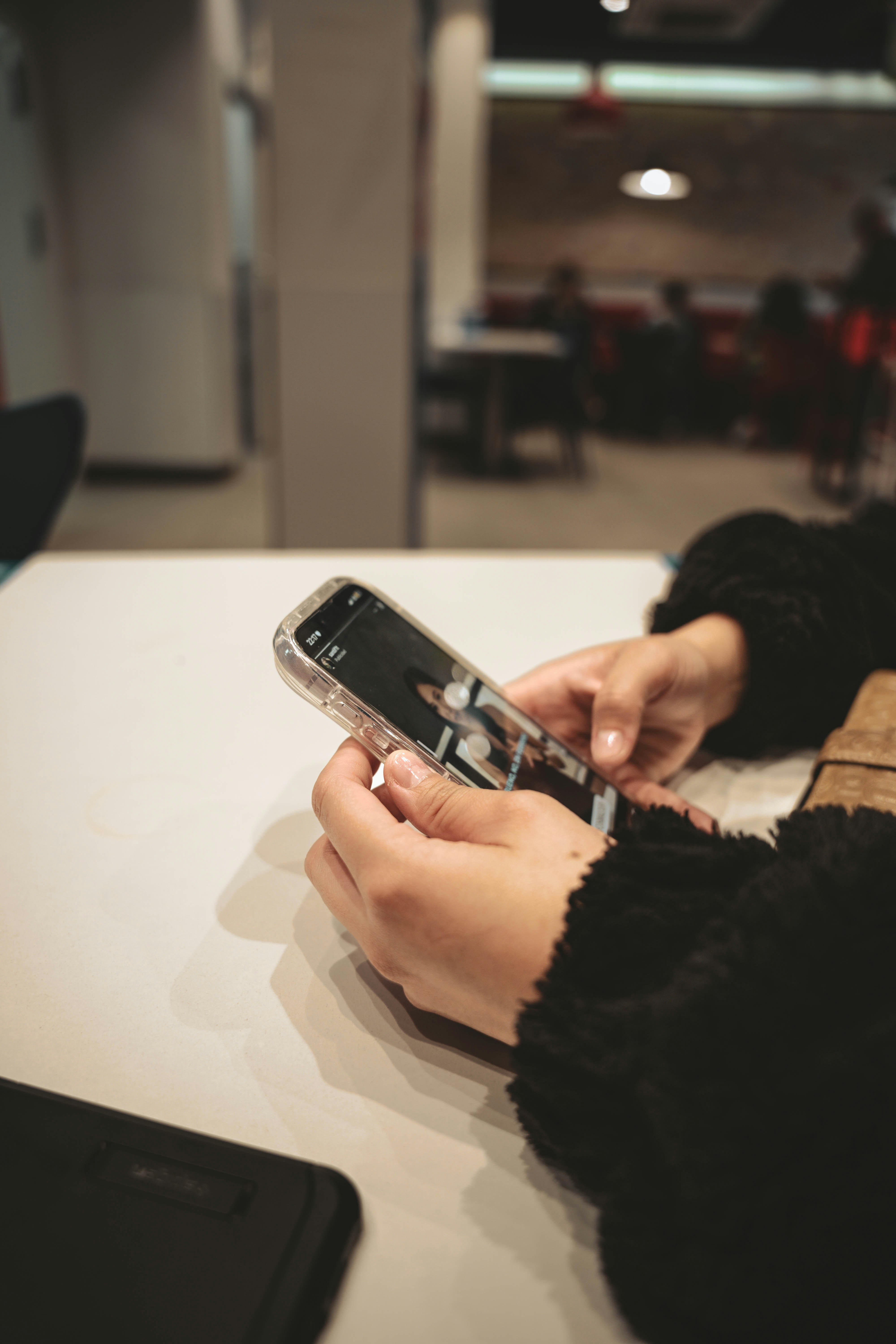 a person holding a cell phone on a table