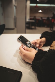 a person holding a cell phone on a table
