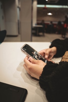 a person holding a cell phone on a table