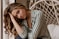 a woman sitting on a bed next to a hammock